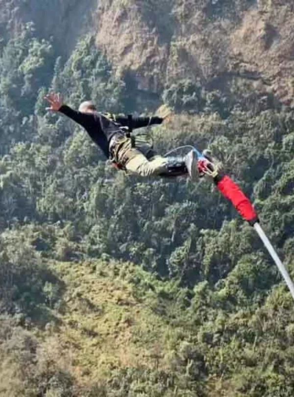 An adventurer jumping from a bridge for bungee jumping in the Nepal mountains.